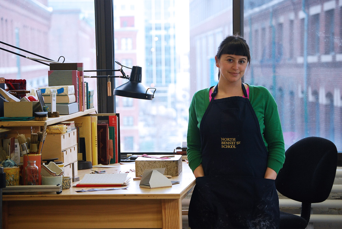 Artist standing at a workbench in a bookbindery.