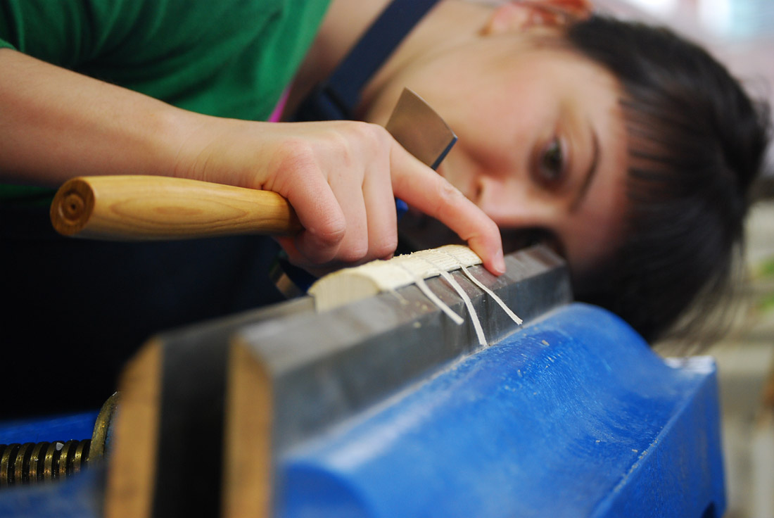 Artist rounding and backing the spine of a binding.