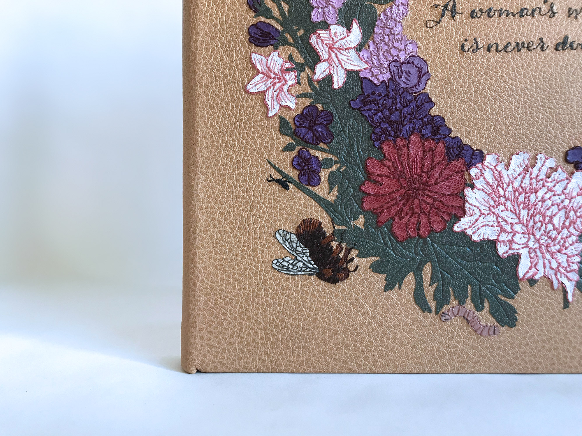 Close-up of front cover of Five Hundred Years of Women’s Work binding on a white table.