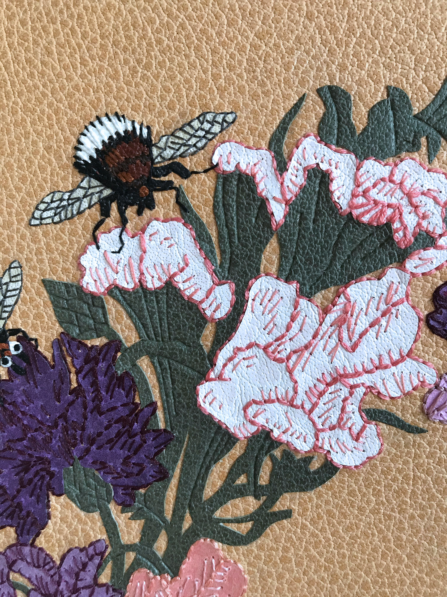 Close-up of front cover of Five Hundred Years of Women’s Work binding on a white table.