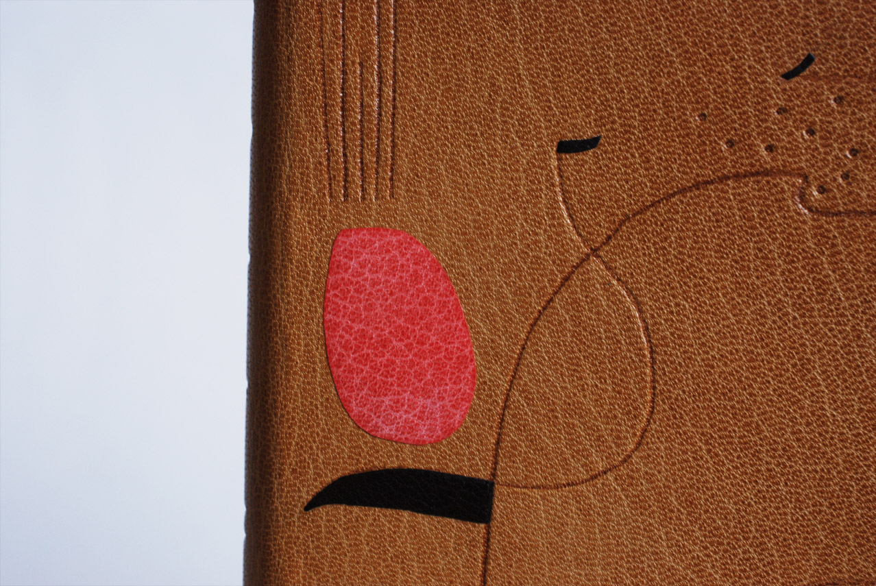 Close-up of front cover of An Alphabet binding on a white table.