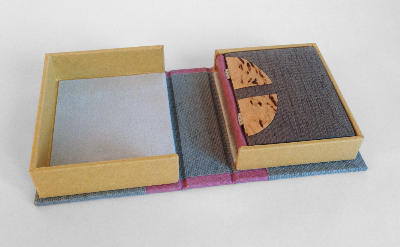 Box interior of Goose Eggs and Other Fowl Expressions binding on a white table.