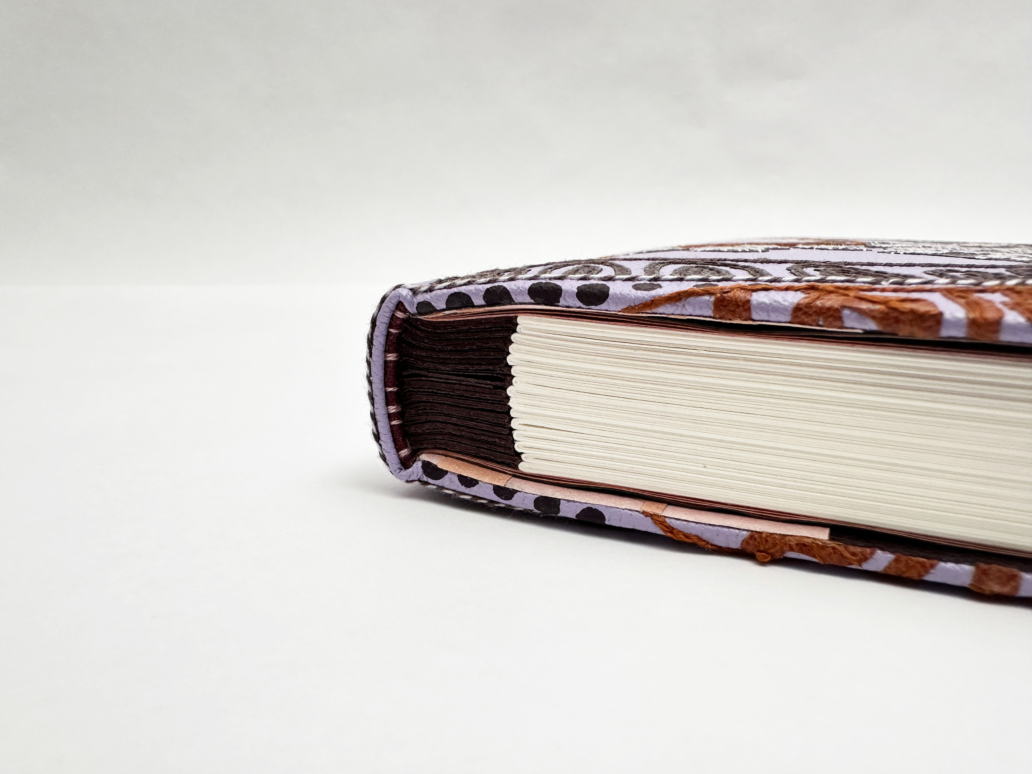 Detail of edge on Helen Fragments binding on a white table.