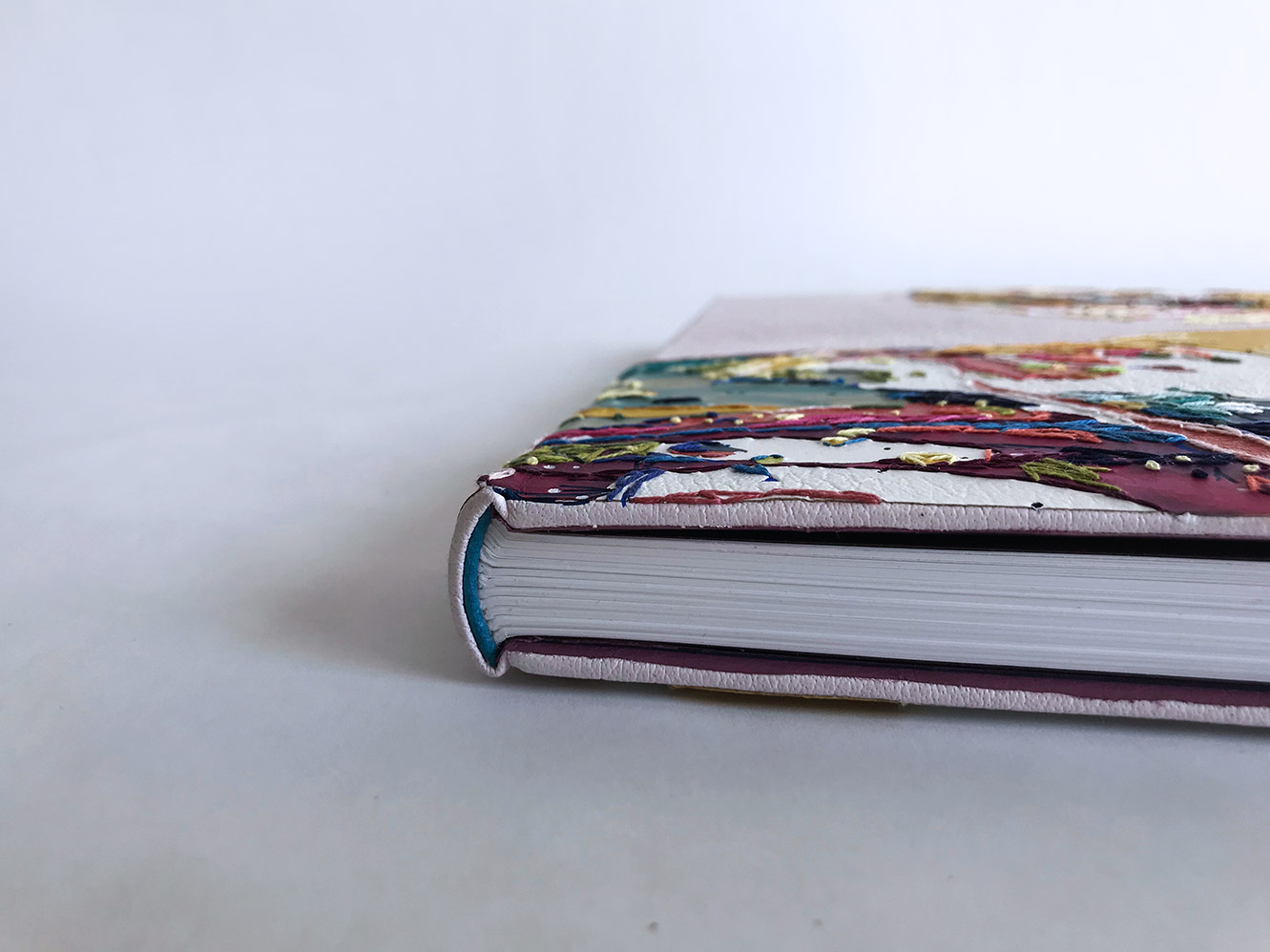 Edge of Human Canvas binding on a white table.