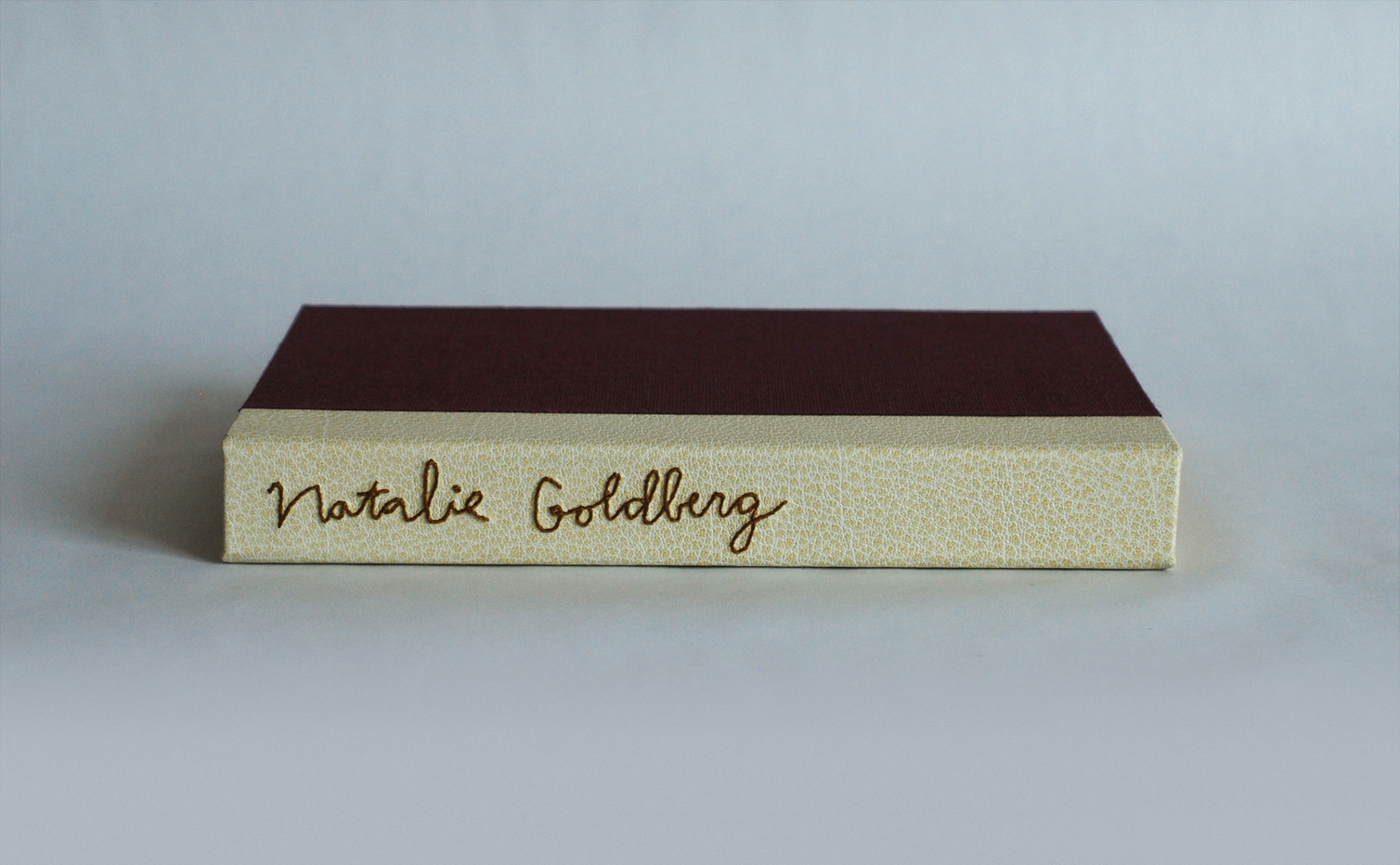 Box spine of Into This World binding on a white table.