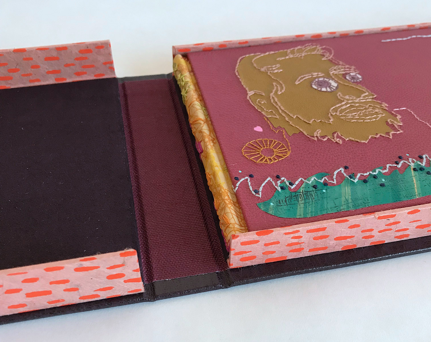 Close-up of box interior of Suspended Whispers binding on a white table.