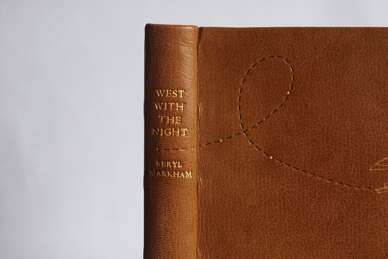 Close-up of front cover of West With the Night binding on a white table.