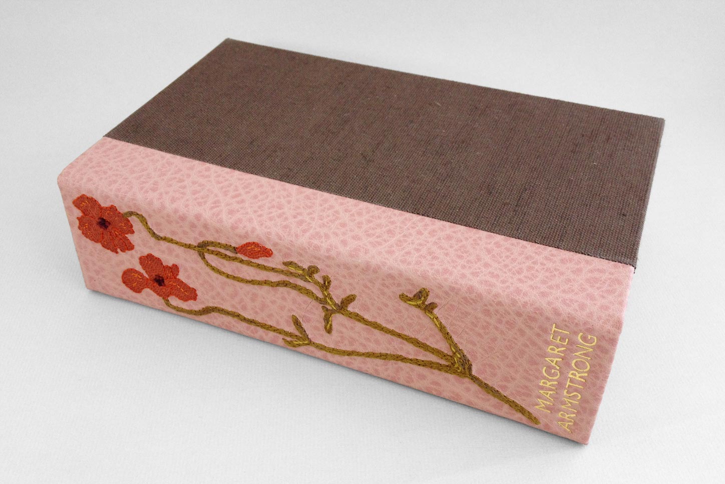 Box spine of Field Book of Western Wild Flowers binding on a white table.