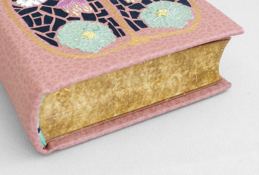 Example of gold leaf, embroidery, and onlays on a binding.