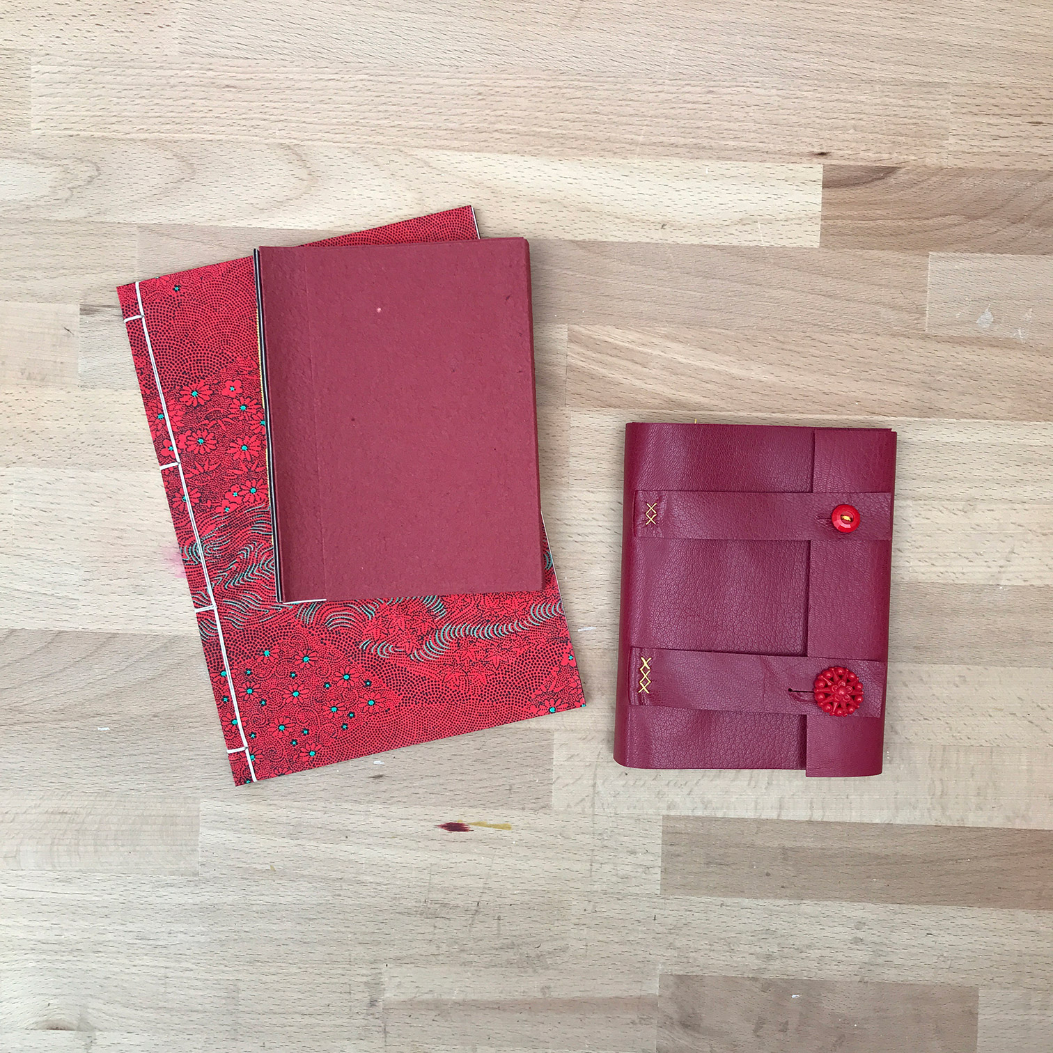 Three blank journals on a wooden table.