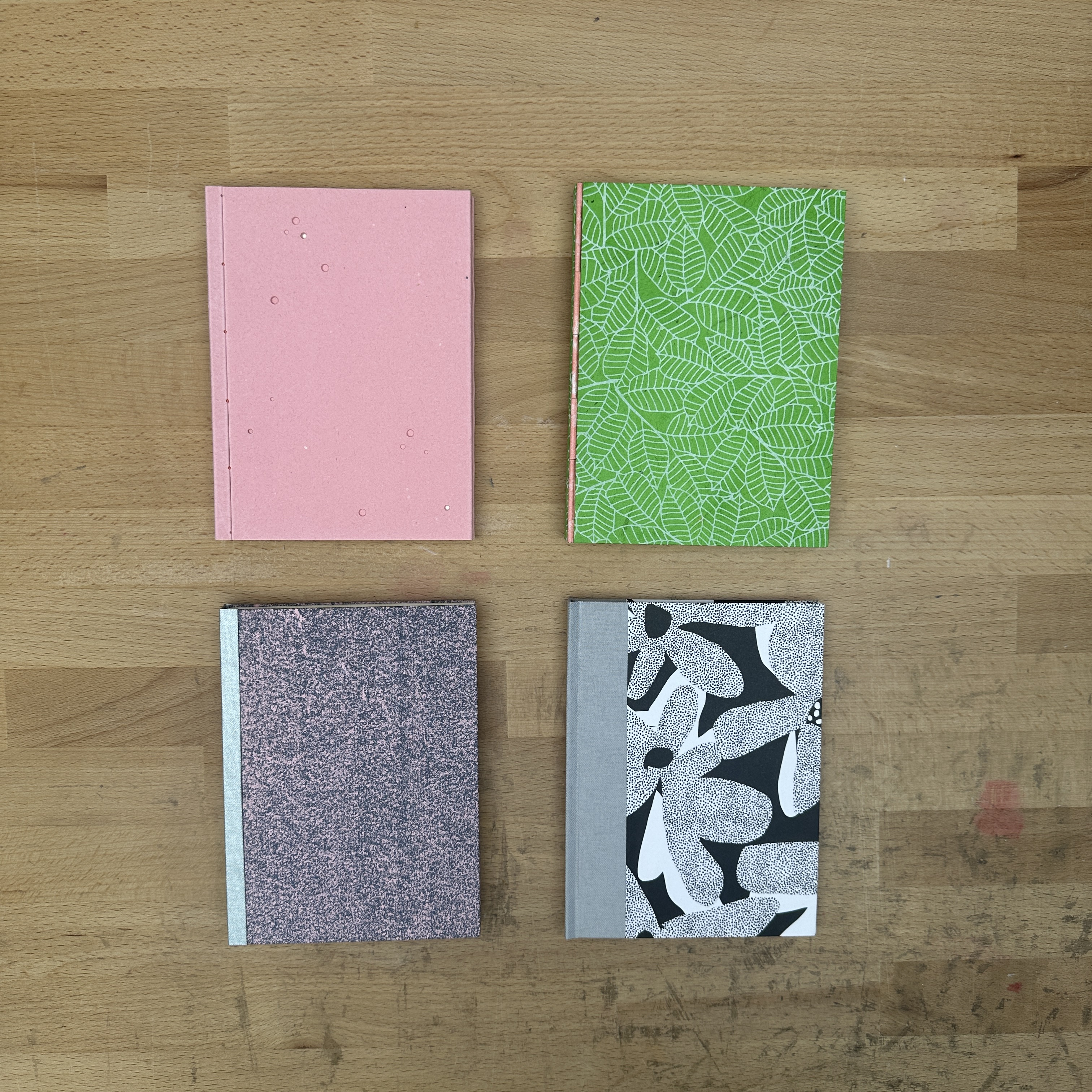 Four books laying flat on a wooden table.