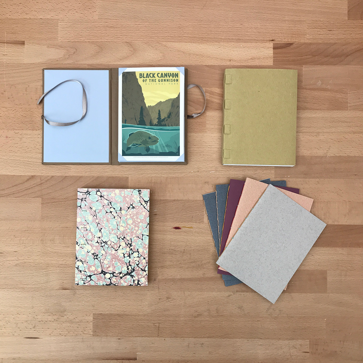 A variety of bindings laying flat on a wooden table.