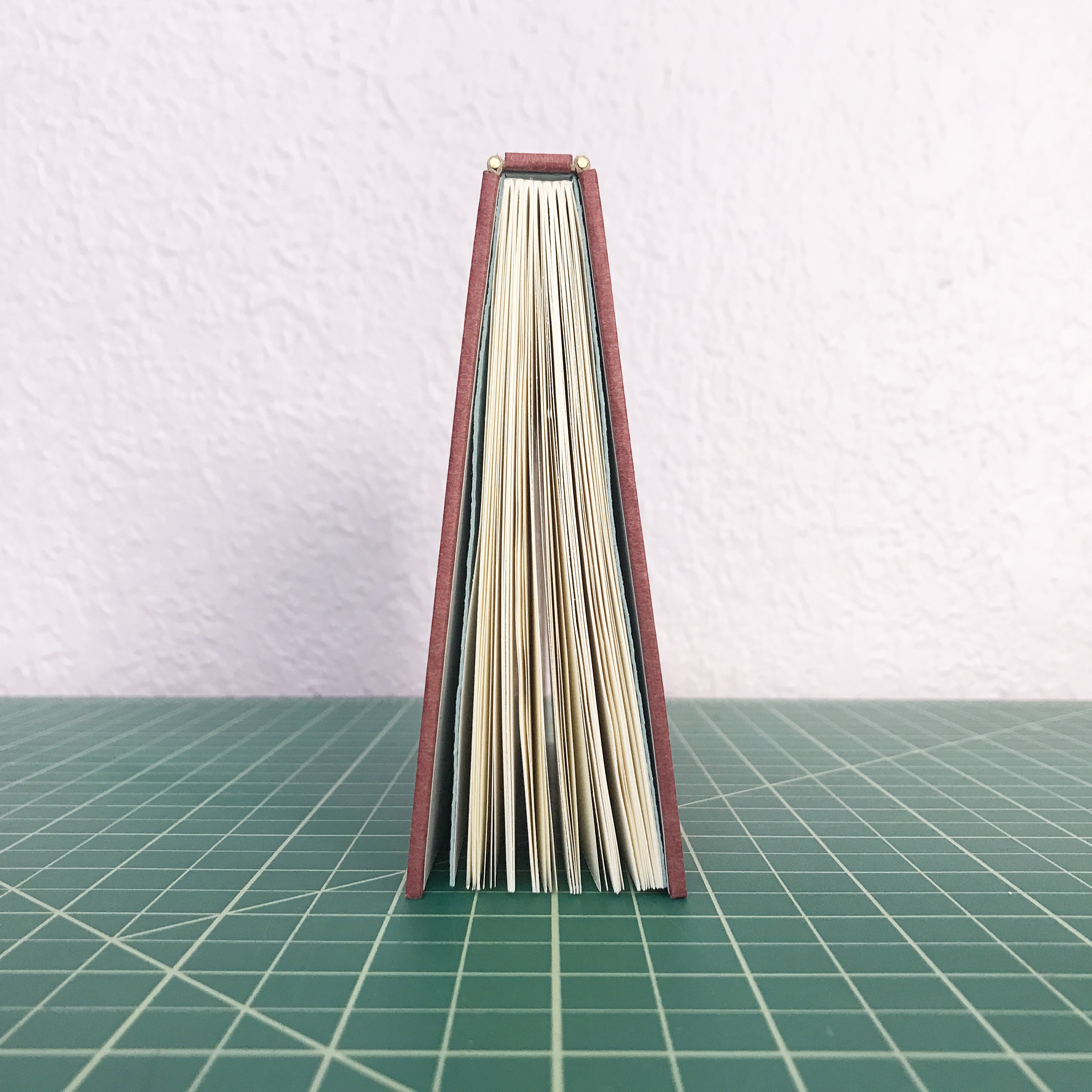 Close-up on the spine of a Pianel Binding sitting on a cutting matte.