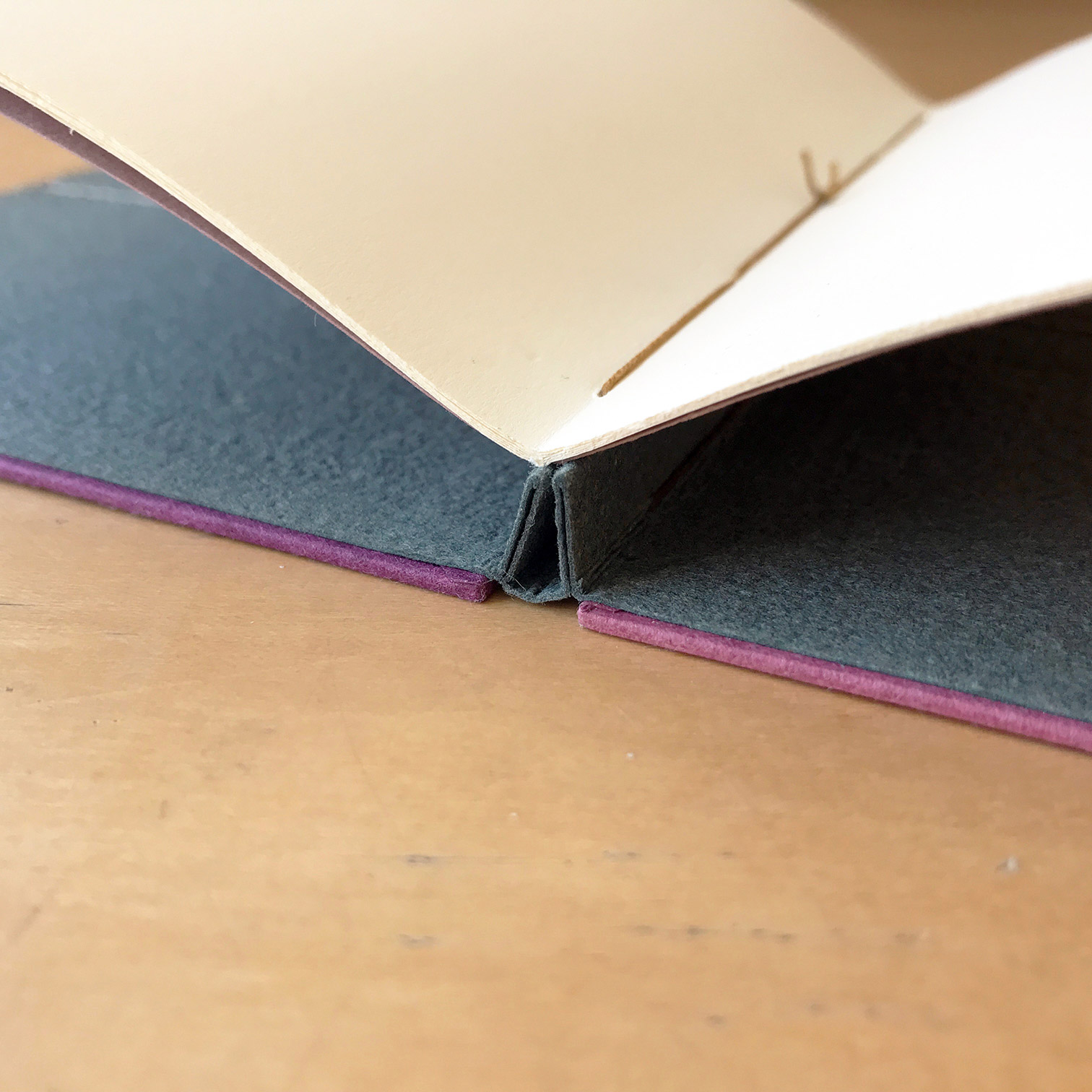 The spine of a Single Signature Binding on a wodden table.